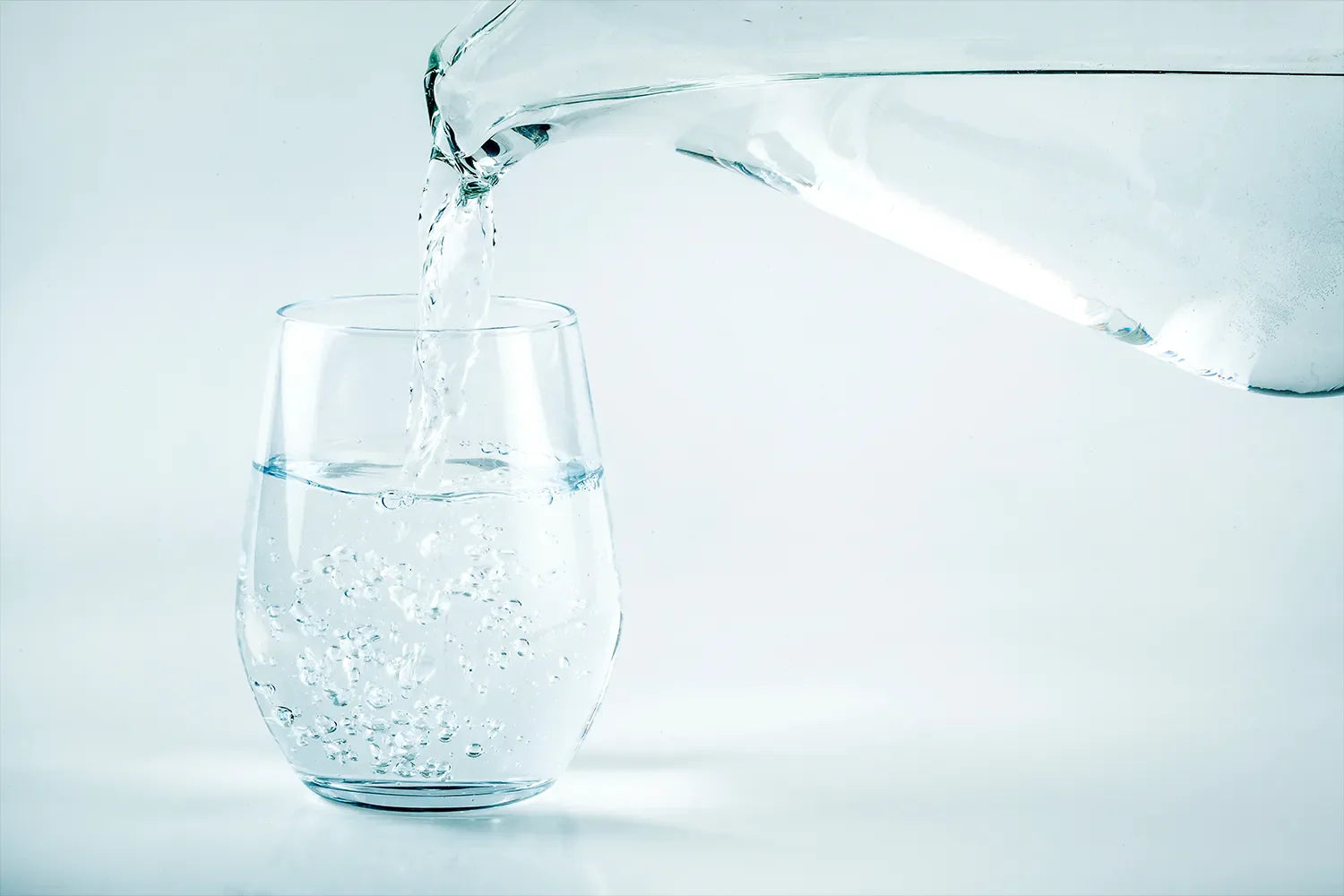 Kanna fyller glas med vatten