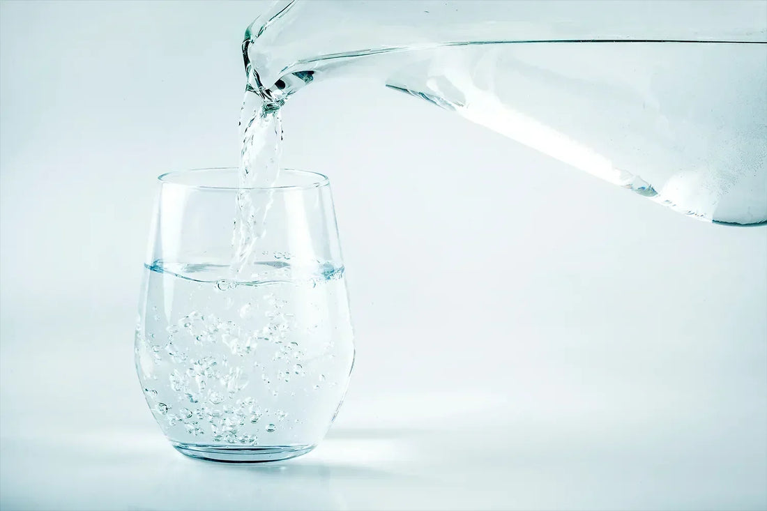 Kanna fyller glas med vatten