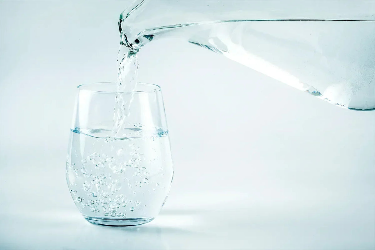 Kanna fyller glas med vatten