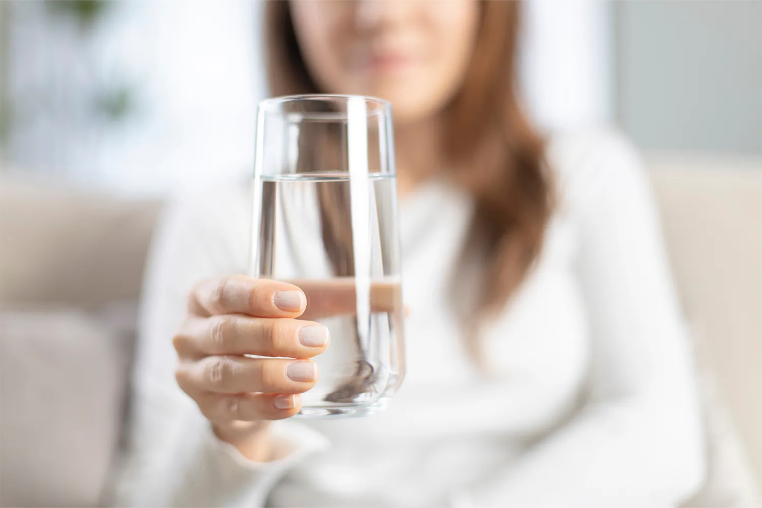 Kvinna håller glas med vatten