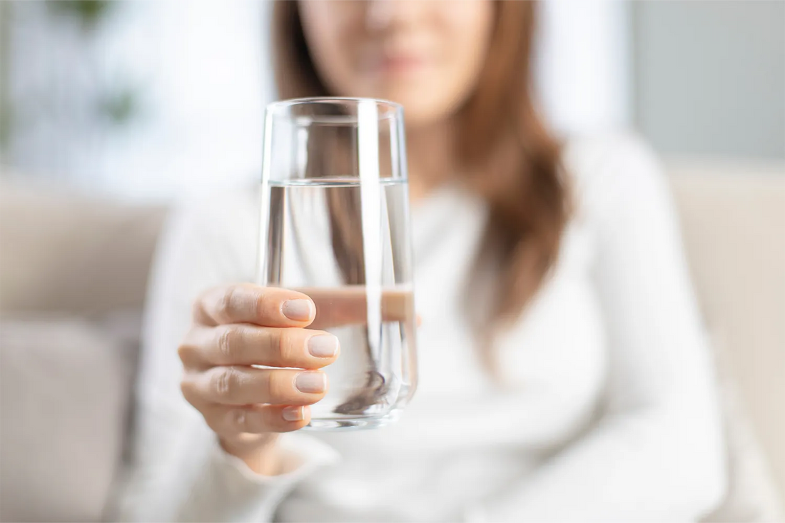 Kvinna håller glas med vatten